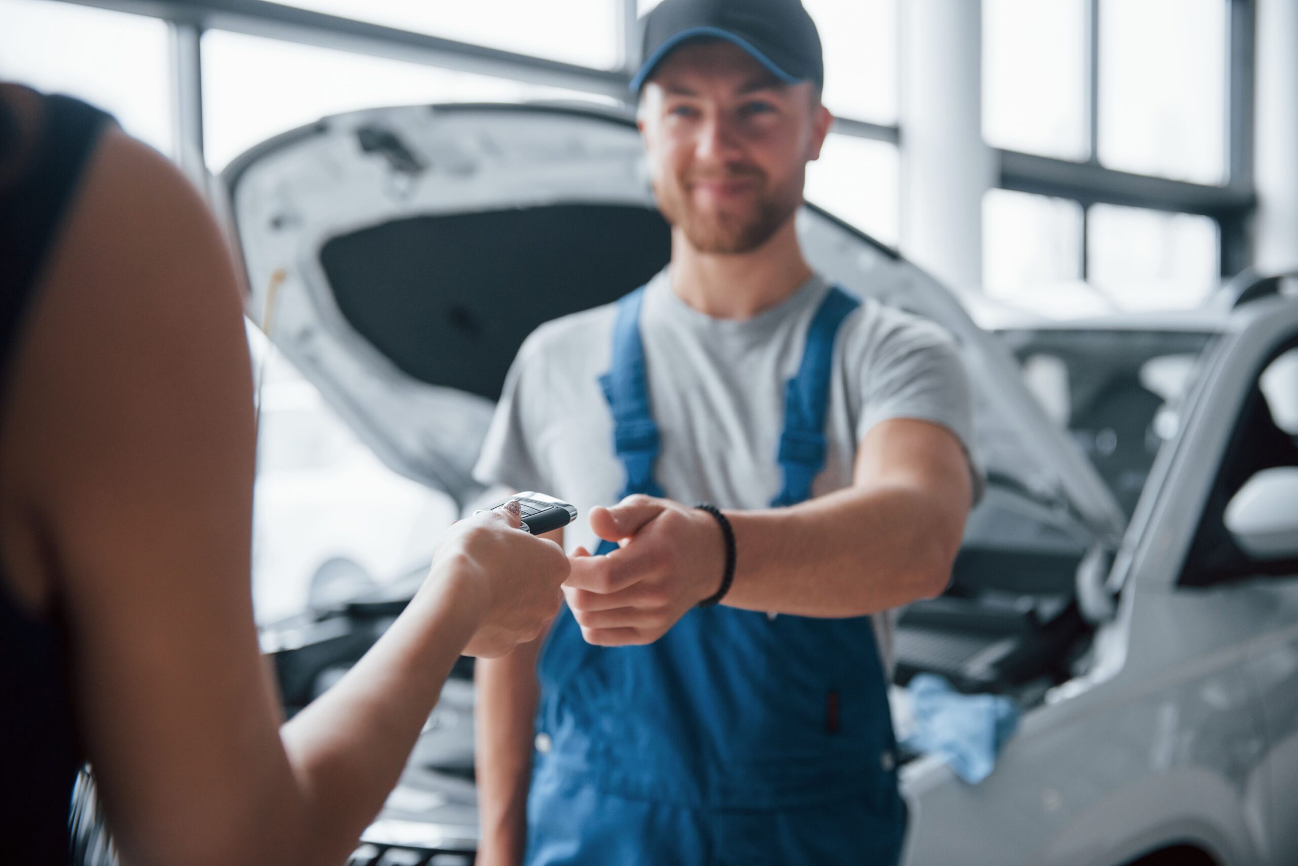no-worries-everything-will-be-okay-woman-auto-salon-with-employee-blue-uniform-taking-her-repaired-car-back